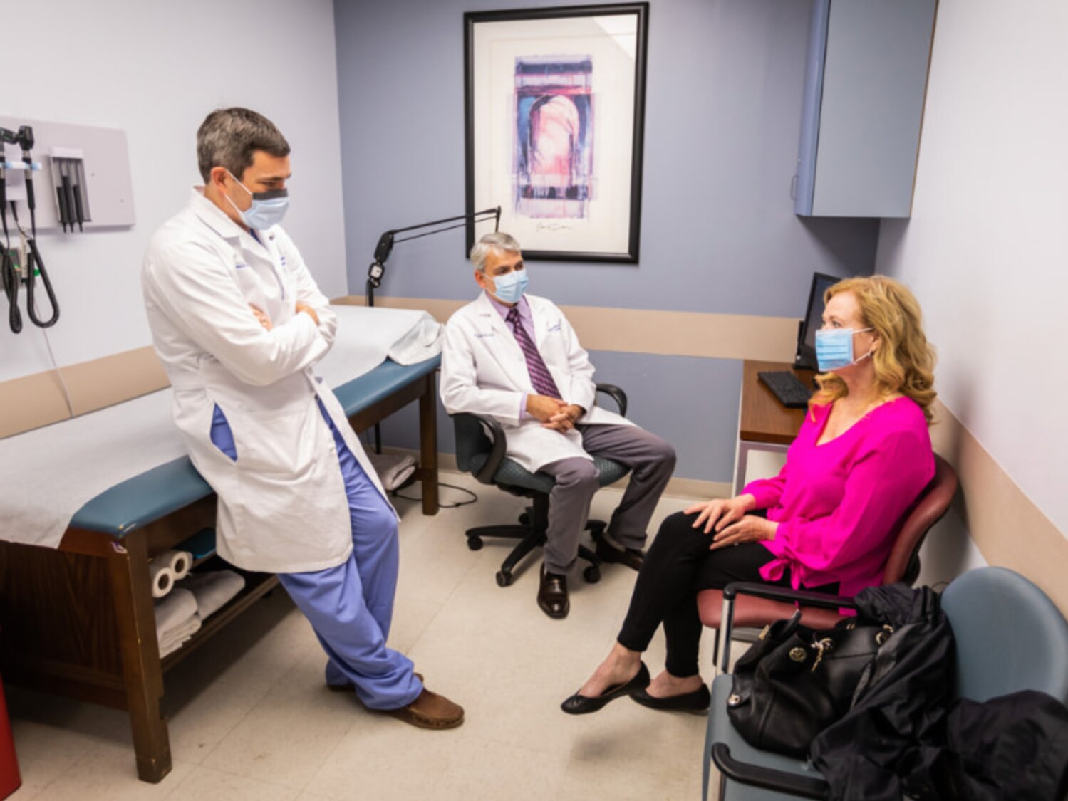 Dr. Chad Washington, left, and Dr. Shashank Shekhar chat with patient Judy Herrington during a clinic visit in 2020.